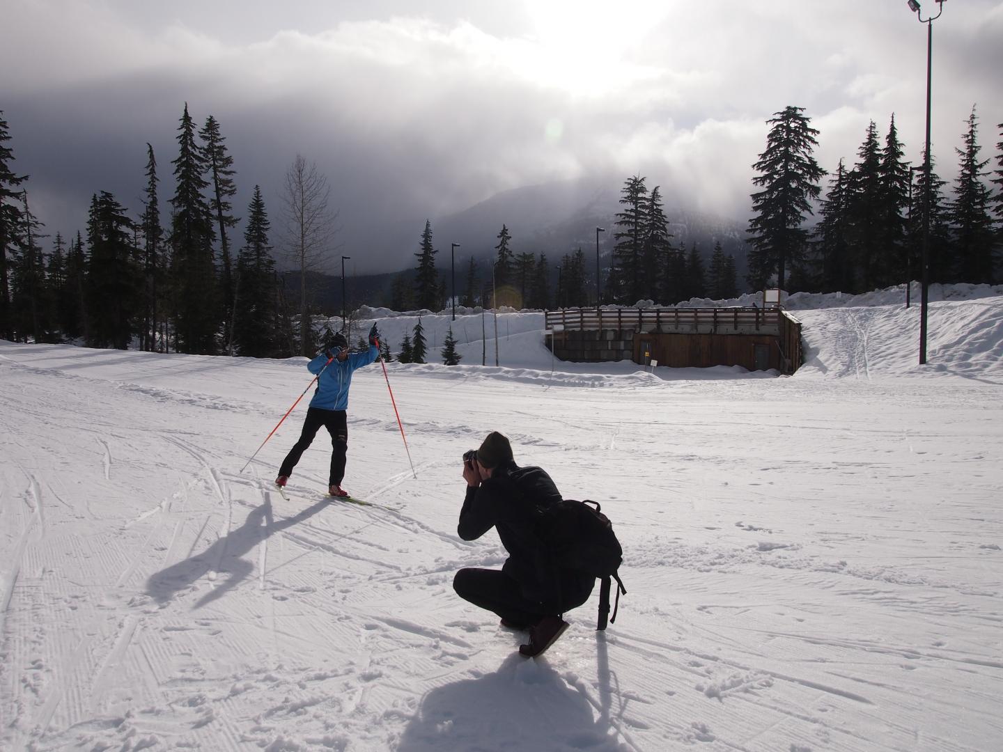 Photographer taking picture of nordic skier on track