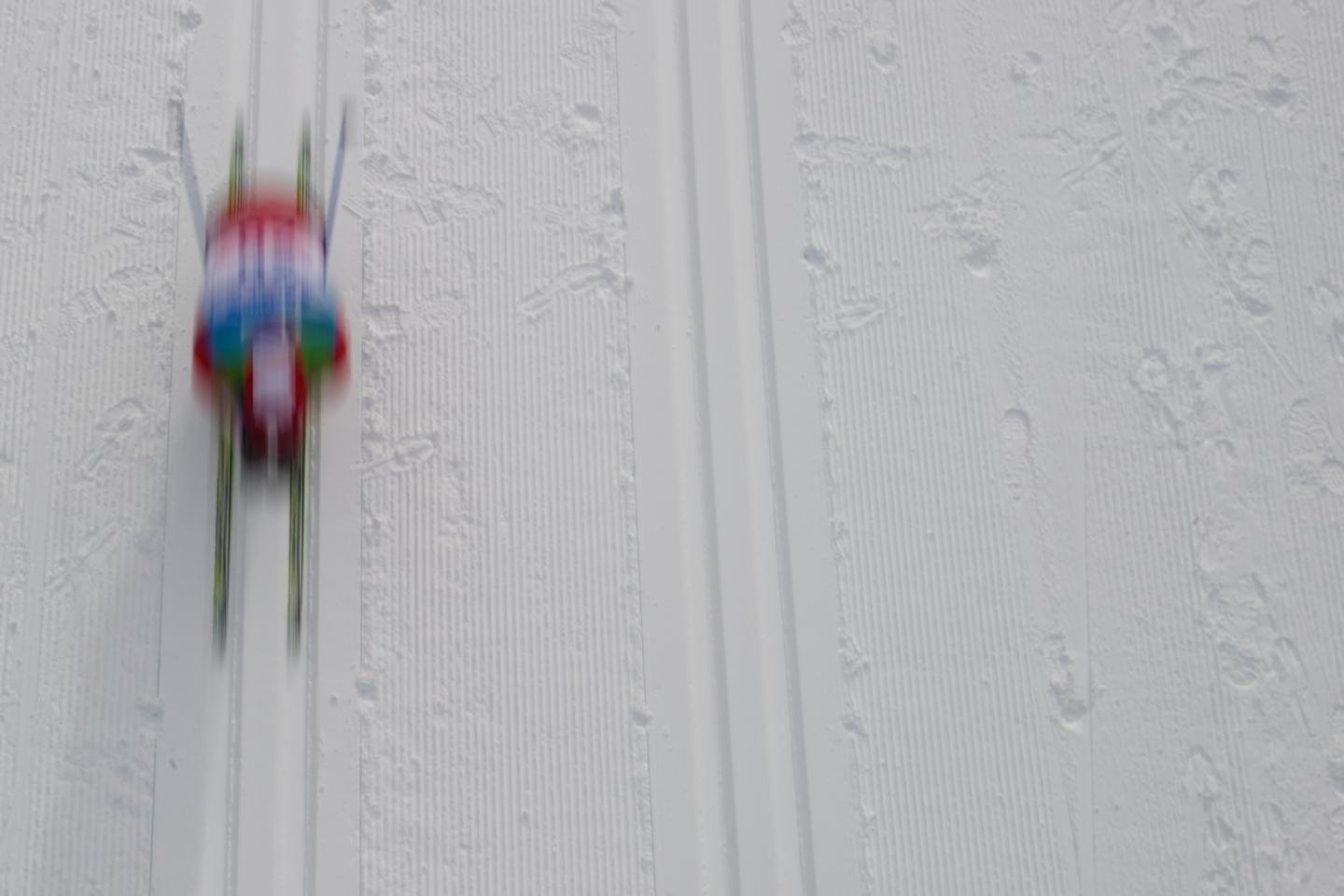 Overhead blurred motion image of skier racing past