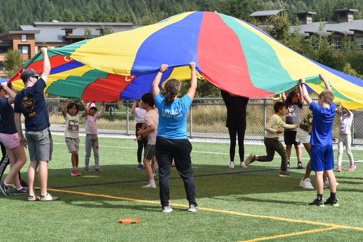 kids playing with rainbow canvas sheet